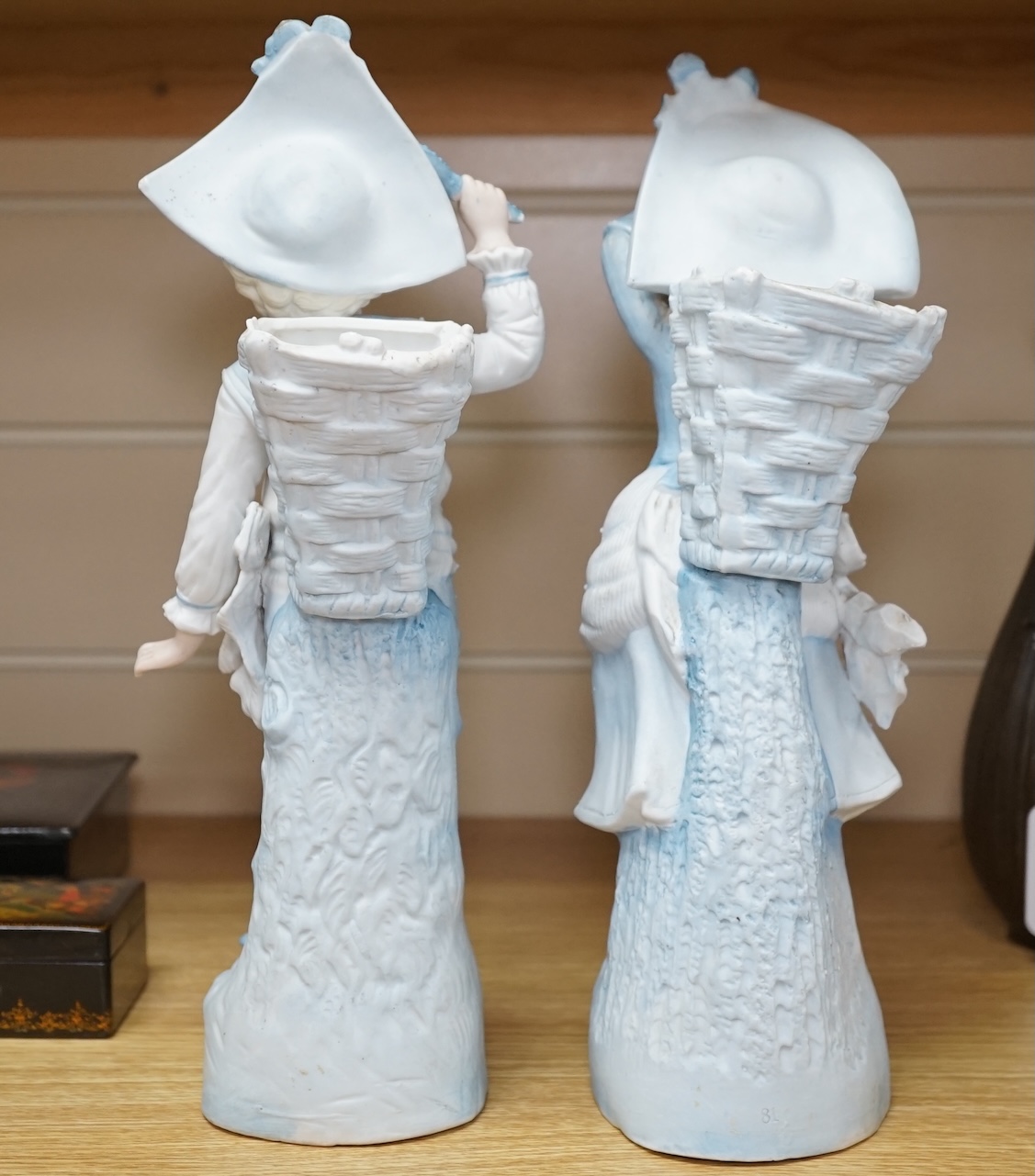 A pair of late 19th century German figurative bisque spill vases, 30cm high. Condition - good